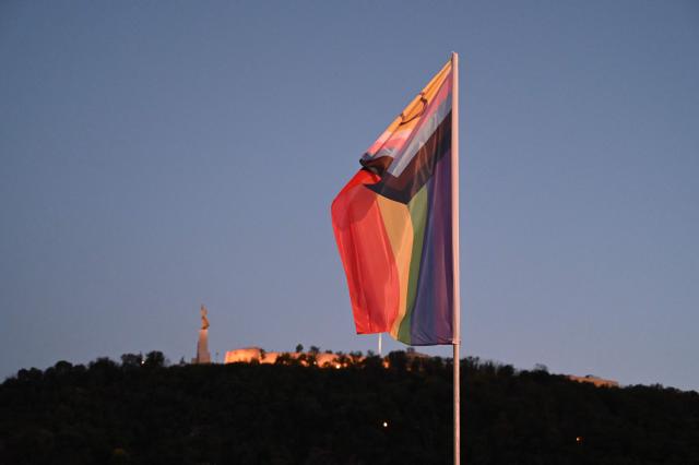 The 'Progress Pride' rainbow flags is seen on the Erzsebet Bridge in Budapest, Hungary, on June 26, 2026, a day before Budapest Pride. A right-wing sympathizer removed several flags and threw them into the Danube, after which activists from far-right parliamentary party, the 'Our Homeland Movement' placed Hungarian national flags on the bridge few days ago. (Photo by Attila KISBENEDEK / AFP)
