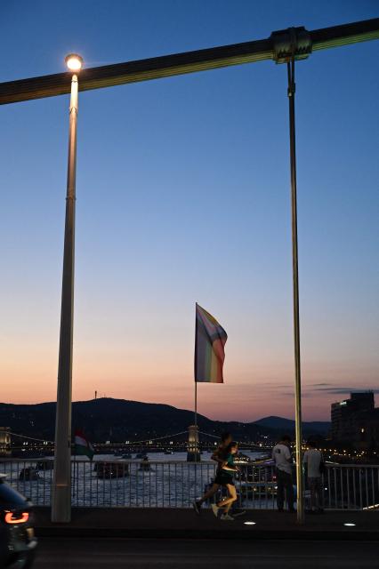The 'Progress Pride' rainbow flags is seen on the Erzsebet Bridge in Budapest, Hungary, on June 26, 2026, a day before Budapest Pride. A right-wing sympathizer removed several flags and threw them into the Danube, after which activists from far-right parliamentary party, the 'Our Homeland Movement' placed Hungarian national flags on the bridge few days ago. (Photo by Attila KISBENEDEK / AFP)