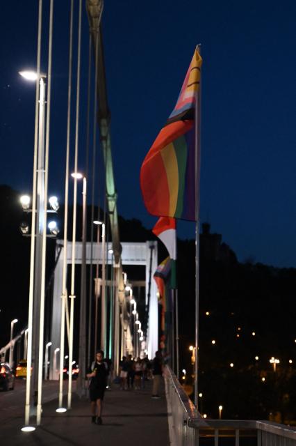 The 'Progress Pride' rainbow flags is seen on the Erzsebet Bridge in Budapest, Hungary, on June 26, 2026, a day before Budapest Pride. A right-wing sympathizer removed several flags and threw them into the Danube, after which activists from far-right parliamentary party, the 'Our Homeland Movement' placed Hungarian national flags on the bridge few days ago. (Photo by Attila KISBENEDEK / AFP)