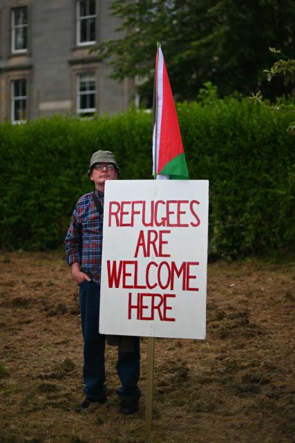 EDITORS NOTE: Graphic content / A protester displays a banner while taking part in an anti-racism "Unity March and Rally", organised by Stand up to Racism, Scotland in Edinburgh on June 27, 2026. (Photo by ANDY BUCHANAN / AFP)