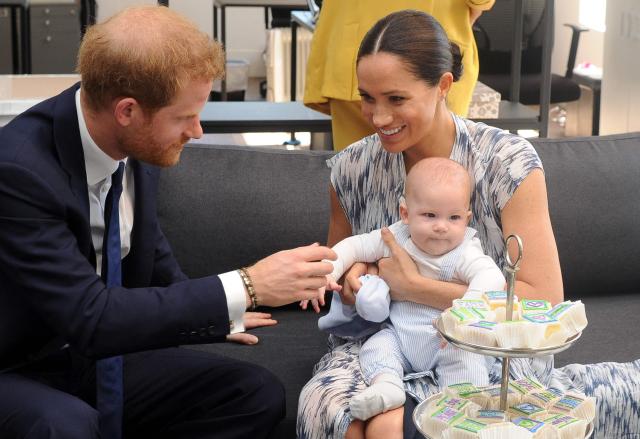 (FILES) Britain's Duke and Duchess of Sussex, Prince Harry and his wife Meghan hold their baby son Archie as they meet with Archbishop Desmond Tutu (unseen) at the Tutu Legacy Foundation in Cape Town on September 25, 2019. Prince Harry, his wife Meghan and two children will stay at royal residences during their first family trip back to the UK in four years in July, a source familiar with the matter said on June 27, 2026. (Photo by HENK KRUGER / POOL / AFP)