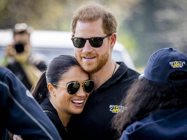 (FILES) Britain's Duke and Duchess of Sussex, Prince Harry (R) and his wife, Meghan Markle embrace at The Invictus Games in The Hague on April 16, 2022. Prince Harry, his wife Meghan and two children will stay at royal residences during their first family trip back to the UK in four years in July, a source familiar with the matter said on June 27, 2026. (Photo by Remko de Waal / ANP / AFP) / Netherlands OUT