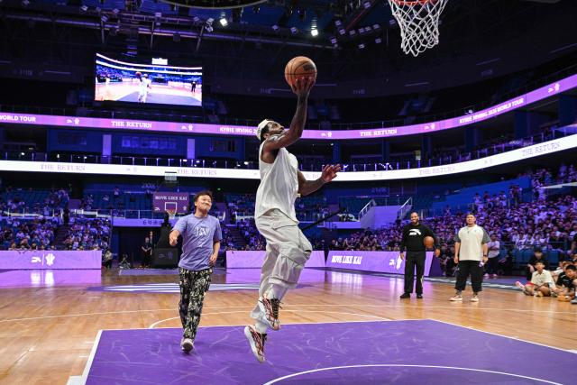 USA's basketball player Kyrie Irving (R) goes for the shot in an event with fans during his World Tour with the Chinese brand ANTA titled "The Return" in Chengdu, in China's southwestern Sichuan province on June 27, 2026. (Photo by Hector RETAMAL / AFP)