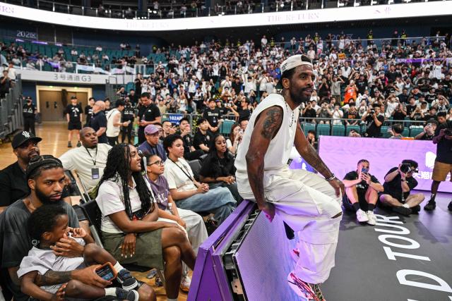 USA's basketball player Kyrie Irving (C) takes a rest in an event with fans during his World Tour with the Chinese brand ANTA titled "The Return" in Chengdu, in China's southwestern Sichuan province on June 27, 2026. (Photo by Hector RETAMAL / AFP)