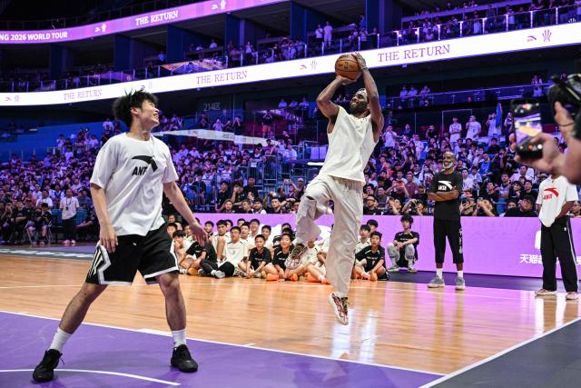 USA's basketball player Kyrie Irving (C) goes for the shot in an event with fans during his World Tour with the Chinese brand ANTA titled "The Return" in Chengdu, in China's southwestern Sichuan province on June 27, 2026. (Photo by Hector RETAMAL / AFP)