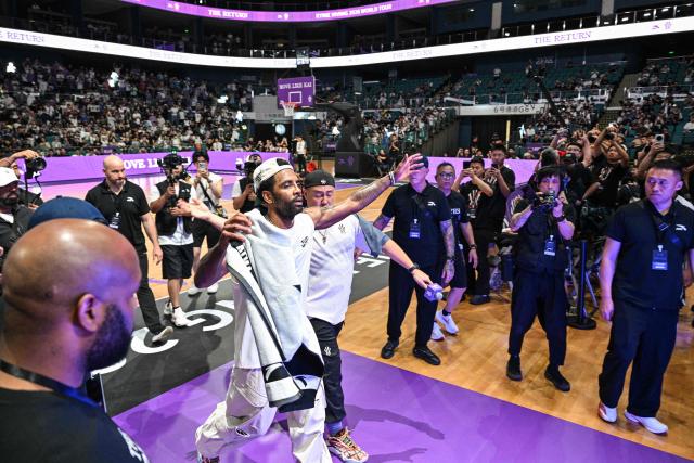 USA's basketball player Kyrie Irving (2L) is seen at the end of an event with fans during his World Tour with the Chinese brand ANTA titled "The Return" in Chengdu, in China's southwestern Sichuan province on June 27, 2026. (Photo by Hector RETAMAL / AFP)