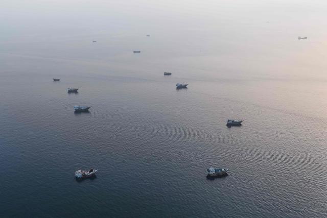 This aerial photograph shows boats anchored off Oman’s northern Musandam Peninsula near the Strait of Hormuz on June 27, 2026. Iran launched attacks on US sites in the Gulf in response to American strikes on the country, state media said on June 27, after Washington accused Tehran of attacking one of its cargo ships in the Strait of Hormuz. The trading of fire raised questions about efforts to keep the crucial waterway open while Washington and Tehran negotiate a final settlement to a war that began on February 28 with US and Israeli strikes on Iran. (Photo by AFP) / 