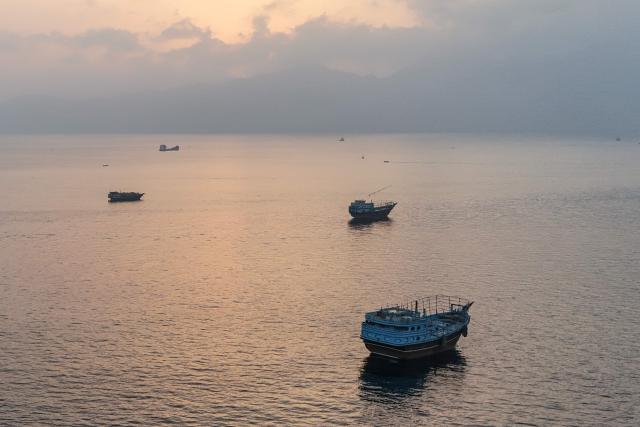 This aerial photograph shows boats anchored off Oman’s northern Musandam Peninsula near the Strait of Hormuz on June 27, 2026. Iran launched attacks on US sites in the Gulf in response to American strikes on the country, state media said on June 27, after Washington accused Tehran of attacking one of its cargo ships in the Strait of Hormuz. The trading of fire raised questions about efforts to keep the crucial waterway open while Washington and Tehran negotiate a final settlement to a war that began on February 28 with US and Israeli strikes on Iran. (Photo by AFP) / 