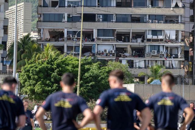 Members of the French Civil Security Training and Intervention Regiment (UIISC 7) look at a partially collapsed building from their base camp at the Karting La Guaira complex in Caraballeda, La Guaira state, Venezuela, on June 27, 2026, as they assist with rescue operations following earthquakes. Nearly 1,000 people have been killed and more than 50,000 remain missing after two consecutive earthquakes in Venezuela, where growing anger has been reported over the lack of official aid to swiftly rescue survivors. (Photo by Miguel MEDINA / POOL / AFP)