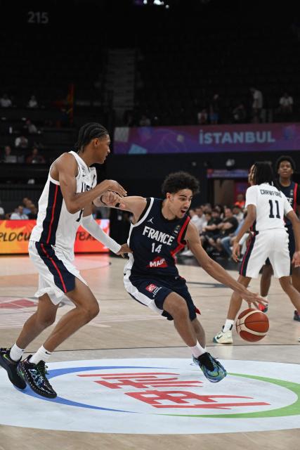 France's #14 Nathan Soliman (R) dribbles past USA's #14 Clarence Rosser Jr (L) during the U17 Basketball World Cup group match between France and USA in Istanbul on June 27, 2026. (Photo by Ozan KOSE / AFP)