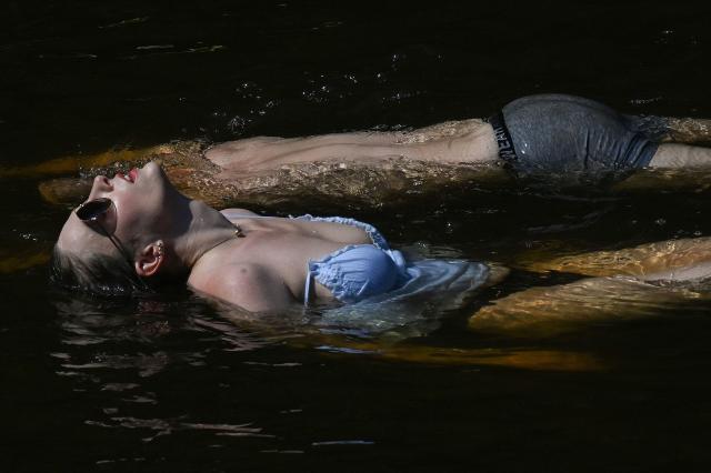 People bathe in the Vltava River in Cesky Krumlov, South Bohemia on June 27, 2026, as a heatwave hits the Czech Republic with temperatures rising over 40 degrees Celsius. The Czech Republic recorded its highest-ever temperature on June 27, 2026, with a reading of 40.6C at a weather station in Doksany north (Photo by Michal Cizek / AFP) / ALTERNATIVE CROP