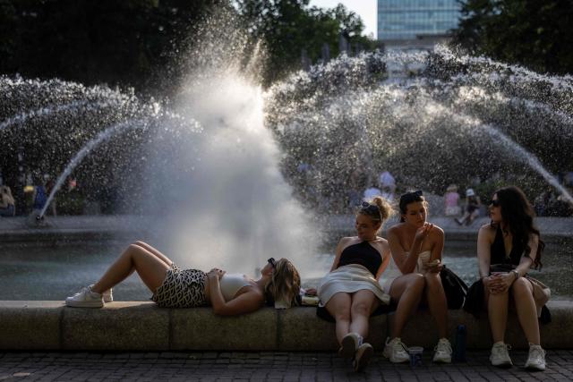 Residents of Warsaw cool off near a fountain in the city centre during the heatwave that has reached Poland on June 27, 2026. (Photo by Wojtek RADWANSKI / AFP)
