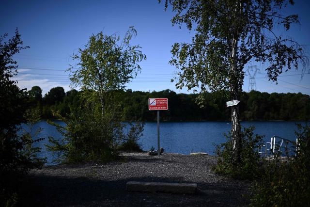 (FILES) (FILES) This picture shows a sign reading 'Swimming prohibited - risk of death' on the enbankment of the FFESSM (Federation Francaise d'Etudes et de Sports Sous-Marins) owned Lac de Ciments in Beaumont-sur-Oise some 40kms north-west of Paris on August 24, 2022. The authorities have recorded 74 deaths by drowning in France since 18 June 2026, linked to the extreme heatwave affecting the country, Interior Minister announces in an interview. (Photo by Christophe ARCHAMBAULT / AFP)