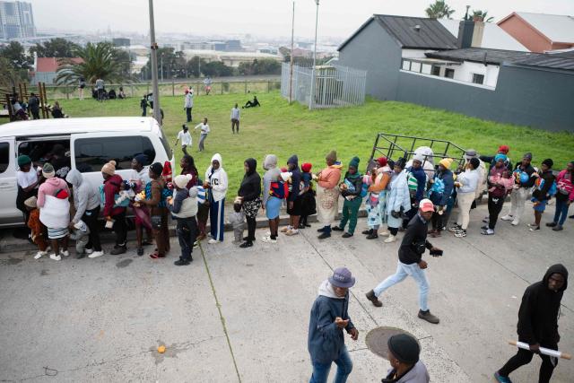 Volunteers hand out diapers as hundreds of Zimbabwean migrants gather with their belongings outside the Zimbabwean Consulate in Cape Town, on June 27, 2026, as they try to get repatriated to Zimbabwe. South Africans President Cyril Ramaphosa vowed on Thursday to crush any attempts to destabilise the nation during planned anti-immigrant marches next week, amid a wave of xenophobia. Citizen-led groups have set Tuesday 30 as a deadline for undocumented foreigners to leave and called for nationwide marches against illegal immigration, marking a crescendo in months of protests that have at times turned violent. (Photo by RODGER BOSCH / AFP)