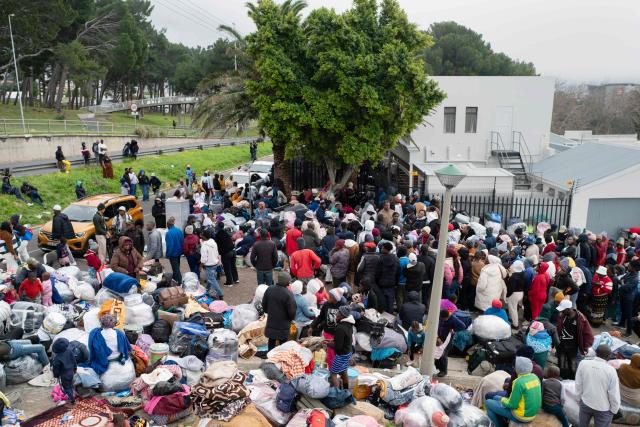 Hundreds of Zimbabwean migrants gather with their belongings outside the Zimbabwean Consulate in Cape Town, on June 27, 2026, as they try to get repatriated to Zimbabwe. South Africans President Cyril Ramaphosa vowed on Thursday to crush any attempts to destabilise the nation during planned anti-immigrant marches next week, amid a wave of xenophobia. Citizen-led groups have set Tuesday 30 as a deadline for undocumented foreigners to leave and called for nationwide marches against illegal immigration, marking a crescendo in months of protests that have at times turned violent. (Photo by RODGER BOSCH / AFP)