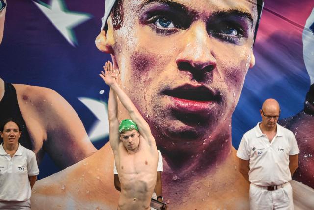 France’s Leon Marchand (C) warms-up as he arrives to compete in the 400m medley final during the French national swimming championships in Saint-Etienne, central France on June 27, 2026. (Photo by OLIVIER CHASSIGNOLE / AFP)
