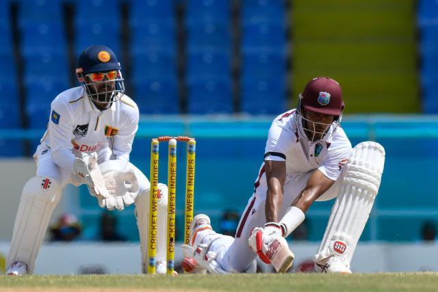 Roston Chase (R) of West Indies hits 4 and Kusal Mendis (L) of Sri Lanka looks on during the 3rd day of the 1st Test between Sri Lanka and West Indies at Vivian Richards Cricket Stadium in North Sound, Antigua and Barbuda, on June 27, 2026. (Photo by Randy Brooks / AFP)