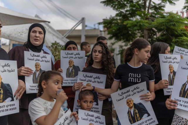 Relatives and activists hold placards as they attend a memorial vigil marking the killing of Arab-Israli teenager Ahmad Jabari in Jaffa on June 27, 2026. Jabari was shot on June 25 by an unidentified man on a scooter while he was working in a local supermarket, according to Israeli police. Another teenager was injured in the incident. (Photo by ilia YEFIMOVICH / AFP)