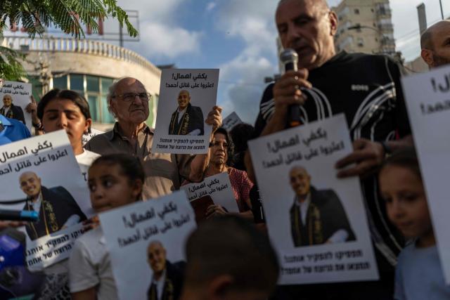 Relatives and activists hold placards as they attend a memorial vigil marking the killing of Arab-Israli teenager Ahmad Jabari in Jaffa on June 27, 2026. Jabari was shot on June 25 by an unidentified man on a scooter while he was working in a local supermarket, according to Israeli police. Another teenager was injured in the incident. (Photo by ilia YEFIMOVICH / AFP)