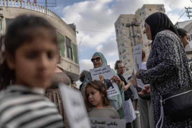Relatives and activists hold placards as they attend a memorial vigil marking the killing of Arab-Israli teenager Ahmad Jabari in Jaffa on June 27, 2026. Jabari was shot on June 25 by an unidentified man on a scooter while he was working in a local supermarket, according to Israeli police. Another teenager was injured in the incident. (Photo by ilia YEFIMOVICH / AFP)