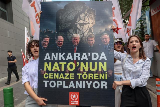 Protesters hold a banner reading "They are meeting for NATO's funeral in Ankara" as they chant slogans against NATO during an anti-NATO demonstration in Ankara, on June 27, 2026 ahead of the NATO summit. The NATO summit will take place in Ankara on July 7-8 and is expected to be attended by 32 leaders including US President. (Photo by ADEM ALTAN / AFP)