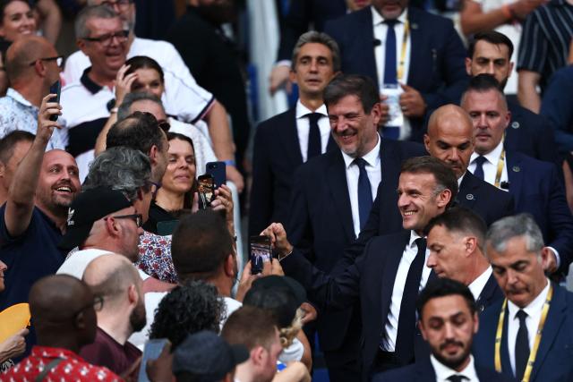 France's President Emmanuel Macron (R) meets spectators prior to the French Top 14 rugby union final between Stade Toulousain (Toulouse) and Montpellier Hérault Rugby (MHR) at the Stade de France in Saint-Denis, on the outskirst of Paris, on June 27, 2026. (Photo by Anne-Christine POUJOULAT / AFP)