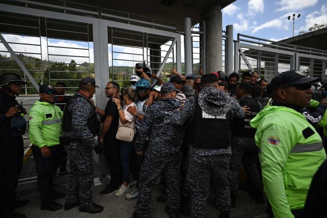 Police officers organize a queue of volunteers at the Poliedro in Caracas on June 27, 2026, as they request permission to travel to La Guaira state to assist with rescue operations following earthquakes. Nearly 1,000 people have been killed and more than 50,000 remain missing after two consecutive earthquakes in Venezuela, where growing anger has been reported over the lack of official aid to swiftly rescue survivors. (Photo by Juan BARRETO / AFP)