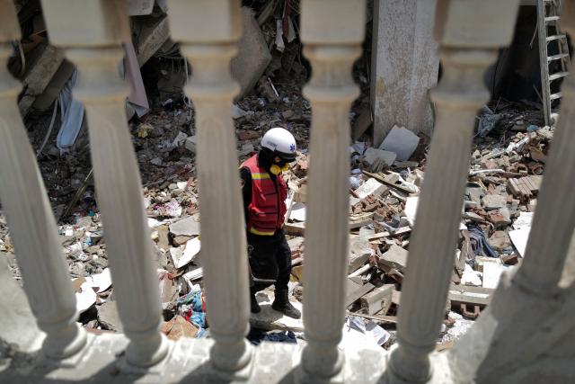 A rescuer walks among debris inside a collapsed building in Caraballeda, La Guaira state, Venezuela, on June 27, 2026, following earthquakes. Nearly 1,000 people have been killed and more than 50,000 remain missing after two consecutive earthquakes in Venezuela, where growing anger has been reported over the lack of official aid to swiftly rescue survivors. (Photo by Mauricio VALENZUELA / AFP)