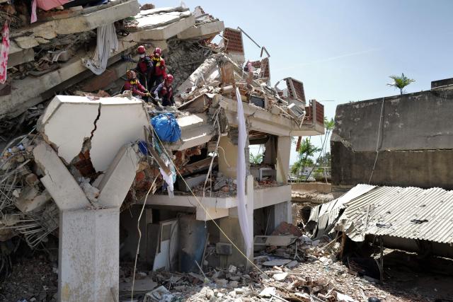 Rescuers work on a collapsed building in Caraballeda, La Guaira state, Venezuela, on June 27, 2026, following earthquakes. Nearly 1,000 people have been killed and more than 50,000 remain missing after two consecutive earthquakes in Venezuela, where growing anger has been reported over the lack of official aid to swiftly rescue survivors. (Photo by Mauricio VALENZUELA / AFP)