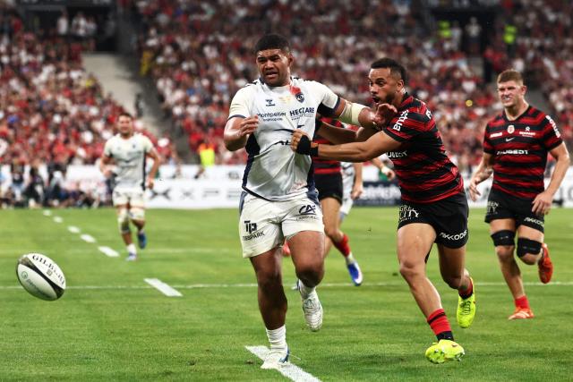 Montpellier’s Australian hooker Jordan Uelese attempts to score a try chased by Toulouse's French wing Matthis Lebel (R) during the French Top 14 rugby union final between Stade Toulousain (Toulouse) and Montpellier Hйrault Rugby (MHR) at the Stade de France in Saint-Denis, on the outskirsts of Paris, on June 27, 2026. (Photo by Anne-Christine POUJOULAT / AFP)