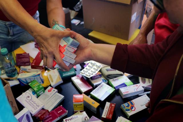 Venezuelans living in Ecuador classify medications donated for the victims of the twin earthquakes in their homeland, at an improvised collection centre in northern Quito, on June 27, 2026. The death toll in Venezuela's twin earthquake disaster reached 1,430, and millions more were feared to lack sanitation and other basic needs as the first US aid flights trickled into Caracas. (Photo by Galo Paguay / AFP)