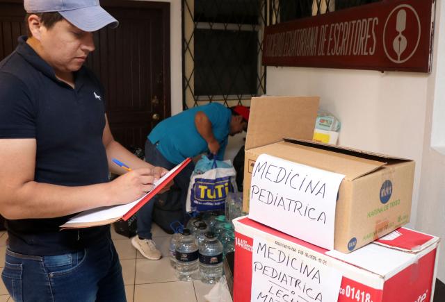A volunteer checks packed medicine as Venezuelans living in Ecuador gather supplies for the victims of the twin earthquakes in their homeland, at an improvised collection centre in northern Quito, on June 27, 2026. The death toll in Venezuela's twin earthquake disaster reached 1,430, and millions more were feared to lack sanitation and other basic needs as the first US aid flights trickled into Caracas. (Photo by Galo Paguay / AFP)