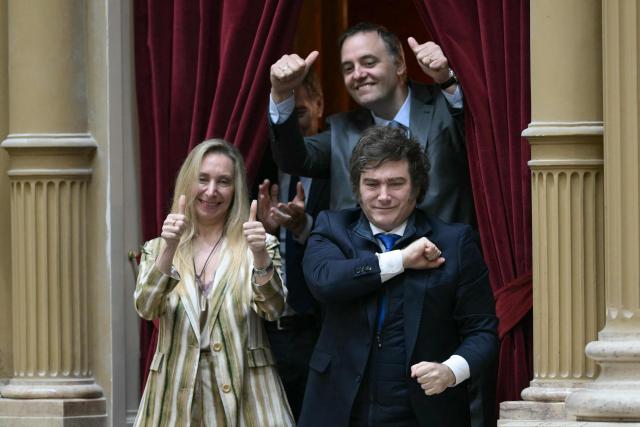 (FILES) Argentinas President Javier Milei (R) gestures as the Secretary General of the Presidency Karina Milei, and the Chief of Cabinet and government spokesman Manuel Adorni, give their thumbs up, during the oath ceremony at the Chamber of Deputies of the Argentine Congress in Buenos Aires on December 3, 2025. Adorni, who earlier this month confessed he had concealed 500,000 US dollars in his sworn statements, sparking an uproar and criticism from figures in the opposition and from within the government itself, presented his resignation on June 27, 2026 in Buenos Aires. (Photo by JUAN MABROMATA / AFP)