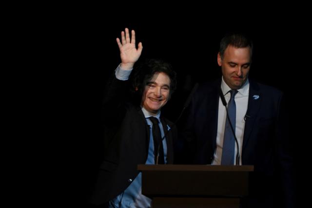 (FILES) Argentine President Javier Milei (L) waves next to Argentina's presidential spokesman Manuel Adorni during the presentation of his new book "Capitalism, Socialism, and the Neoclassical Trap" at the Luna Park stadium in Buenos Aires on May 22, 2024. Adorni, who earlier this month confessed he had concealed 500,000 US dollars in his sworn statements, sparking an uproar and criticism from figures in the opposition and from within the government itself, presented his resignation on June 27, 2026 in Buenos Aires. (Photo by LUIS ROBAYO / AFP)