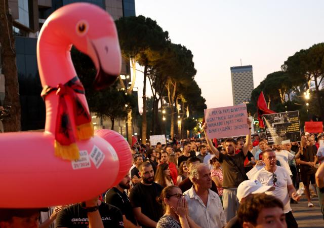 People demonstrate holding an inflatable flamingo and placards in front of Albania's Prime Minister's office against a planned resort linked to US President's family, in Tirana on June 27, 2026. Since late May, protesters have gathered every evening to oppose the construction of a luxury hotel linked to Trump's daughter Ivanka and her husband Jared Kushner, planned in a nature reserve on the Balkan nation's coast. (Photo by Adnan Beci / AFP)