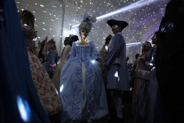 Attendees wearing period costumes take part in the 14th edition of The Grand Masked Ball clubbing event in the Orangerie of the Chateau de Versailles in Versailles, southwest of Paris, on June 27, 2026. (Photo by Charlotte SIEMON / AFP)
