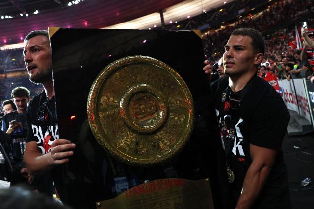 Toulouse's French scrum-half Antoine Dupont (R) and Toulouse's French flanker Francois Cros (L) bring the "Bouclier de Brennus" trophy to supporters after winning the French Top 14 rugby union final against Montpellier Hérault Rugby (MHR) at the Stade de France in Saint-Denis, on the outskirts of Paris, on June 27, 2026. (Photo by Anne-Christine POUJOULAT / AFP)