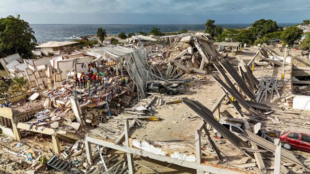 This aerial picture shows buildings destroyed during twin earthquakes, in Caraballeda, La Guaira State, Venezuela, on June 27, 2026. The death toll in Venezuela's June 24 twin earthquake disaster reached 1,430 on June 27, and millions more were feared to lack sanitation and other basic needs, as the first US aid flights landed in Caracas. (Photo by Miguel MEDINA / POOL / AFP)