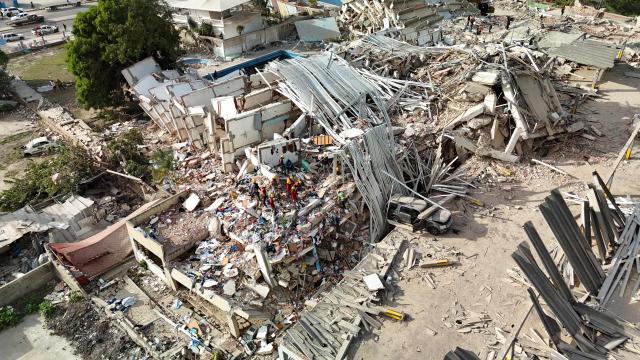This aerial picture shows buildings destroyed during twin earthquakes, in Caraballeda, La Guaira State, Venezuela, on June 27, 2026. The death toll in Venezuela's June 24 twin earthquake disaster reached 1,430 on June 27, and millions more were feared to lack sanitation and other basic needs, as the first US aid flights landed in Caracas. (Photo by Miguel MEDINA / POOL / AFP)
