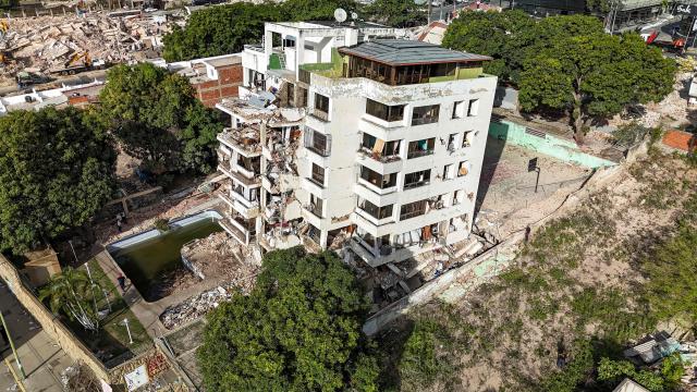 This aerial picture shows a building destroyed during twin earthquakes, in Caraballeda, La Guaira State, Venezuela, on June 27, 2026. The death toll in Venezuela's June 24 twin earthquake disaster reached 1,430 on June 27, and millions more were feared to lack sanitation and other basic needs, as the first US aid flights landed in Caracas. (Photo by Miguel MEDINA / POOL / AFP)