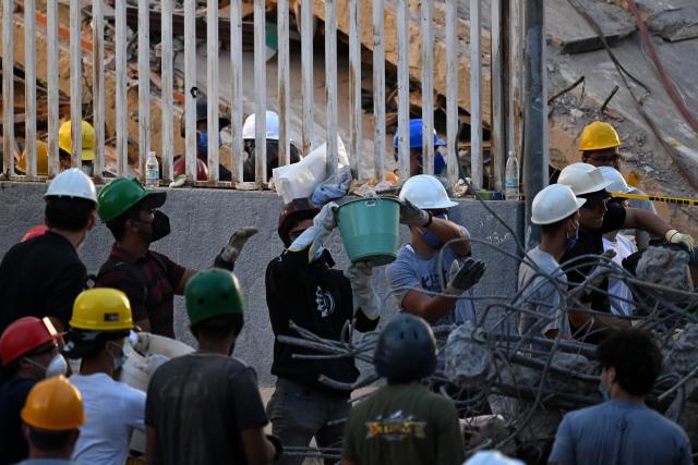 Volunteers search for possible victims at a collapsed building following twin earthquakes, in San Bernardino neighbourhood, in Caracas on June 27, 2026. The death toll in Venezuela's June 24 twin earthquake disaster reached 1,430, and millions more were feared to lack sanitation and other basic needs, as the first US aid flights landed in Caracas. (Photo by Juan BARRETO / AFP)