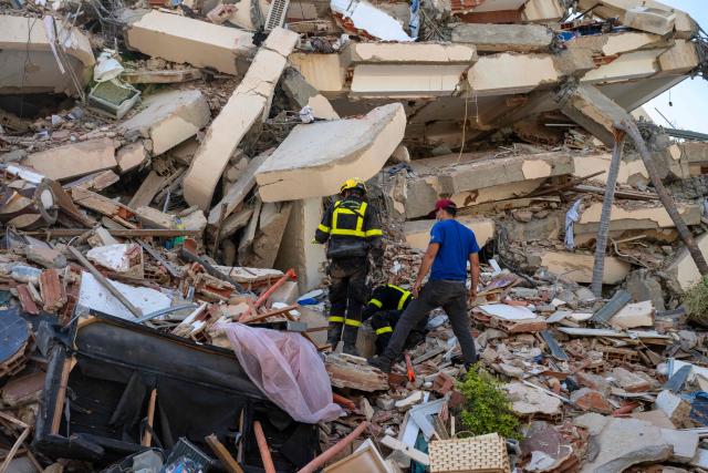 Members of the French Civil Security Training and Intervention Regiment (UIISC 7) gather in fron of a damaged building by the earthquake in Caraballeda, La Guaira state, Venezuela, on June 27, 2026. Nearly 1,000 people have been killed and more than 50,000 remain missing after two consecutive earthquakes in Venezuela, where growing anger has been reported over the lack of official aid to swiftly rescue survivors. (Photo by Miguel MEDINA / POOL / AFP)