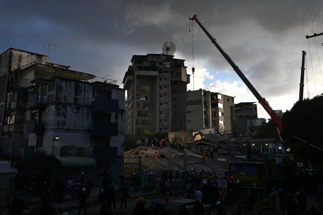 Volunteers and rescuers work in search operations at a collapsed building following twin earthquakes, in San Bernardino neighbourhood, in Caracas on June 27, 2026. The death toll in Venezuela's June 24 twin earthquake disaster reached 1,430, and millions more were feared to lack sanitation and other basic needs, as the first US aid flights landed in Caracas. (Photo by Juan BARRETO / AFP)