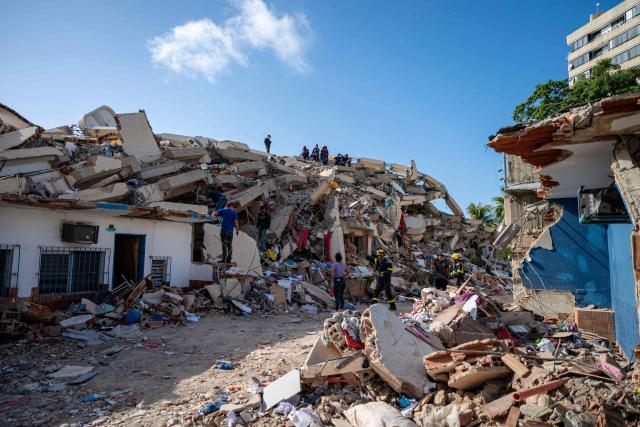 Members of the French Civil Security Training and Intervention Regiment (UIISC 7) help residents in the search for victims in Caraballeda, La Guaira state, Venezuela, on June 27, 2026, following earthquakes. Nearly 1,000 people have been killed and more than 50,000 remain missing after two consecutive earthquakes in Venezuela, where growing anger has been reported over the lack of official aid to swiftly rescue survivors. (Photo by Miguel MEDINA / POOL / AFP)