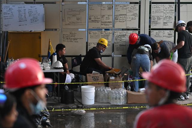 Volunteers arrange supplies nearby a collapsed building following twin earthquakes, in San Bernardino neighbourhood, in Caracas on June 27, 2026. (Photo by Juan BARRETO / AFP)