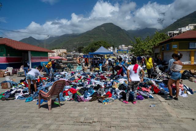 Clothes are offered for free at a square next to the Karting La Guaira complex in Caraballeda, La Guaira state, Venezuela, on June 27, 2026, following twin earthquakes. Nearly 1,000 people have been killed and more than 50,000 remain missing after two consecutive earthquakes in Venezuela, where growing anger has been reported over the lack of official aid to swiftly rescue survivors. (Photo by Miguel MEDINA / POOL / AFP)