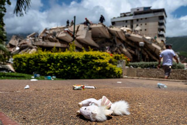 A stuffed doll lies near a damaged building in La Guaira complex in Caraballeda, La Guaira state, Venezuela, on June 27, 2026, following twin earthquakes. Nearly 1,000 people have been killed and more than 50,000 remain missing after two consecutive earthquakes in Venezuela, where growing anger has been reported over the lack of official aid to swiftly rescue survivors. (Photo by Miguel MEDINA / POOL / AFP)