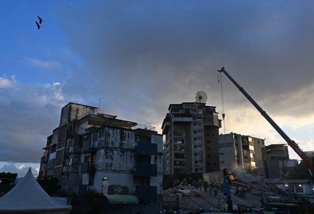 Two birds overfly the site of a collapsed building following twin earthquakes, in San Bernardino neighbourhood, in Caracas on June 27, 2026. The death toll in Venezuela's June 24 twin earthquake disaster reached 1,430, and millions more were feared to lack sanitation and other basic needs, as the first US aid flights landed in Caracas. (Photo by Juan BARRETO / AFP)
