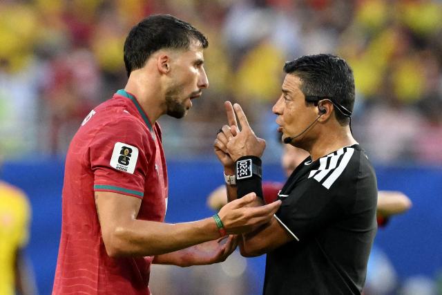 Portugal's defender #03 Ruben Dias (L) and Australian referee Alireza Faghani (R) talk during the 2026 World Cup Group K football match between Colombia and Portugal at the Miami Stadium in Miami Gardens on June 27, 2026.  (Photo by ROBERTO SCHMIDT / AFP)