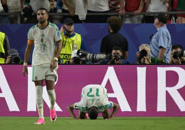 Algeria's defender #17 Rafik Belghali kneels on the pitch as he celebrates scoring his team's first goal during the 2026 World Cup Group J football match between Algeria and Austria at the Kansas City Stadium in Kansas City on June 27, 2026.  (Photo by JUAN MABROMATA / AFP)